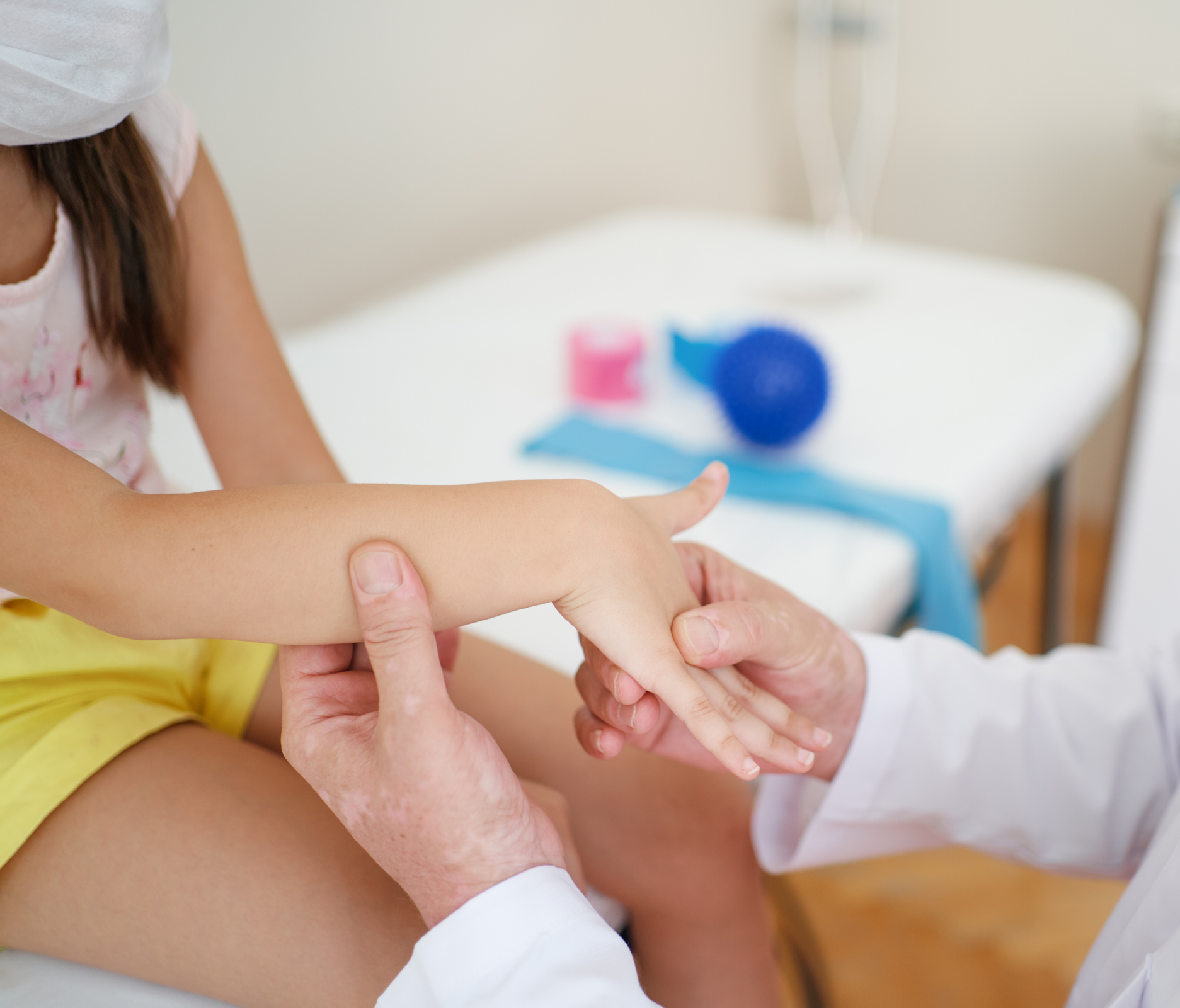 Wrist massage. A male massage therapist puts pressure on a sensitive point on a kid's hand.