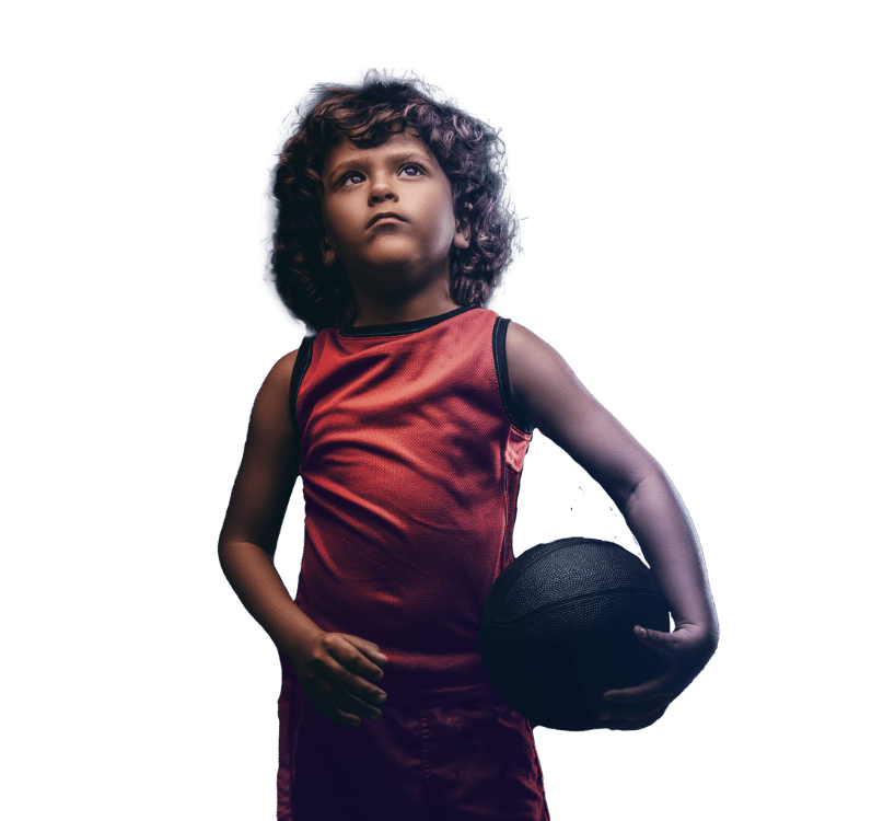 a young boy holding a basketball and looking up