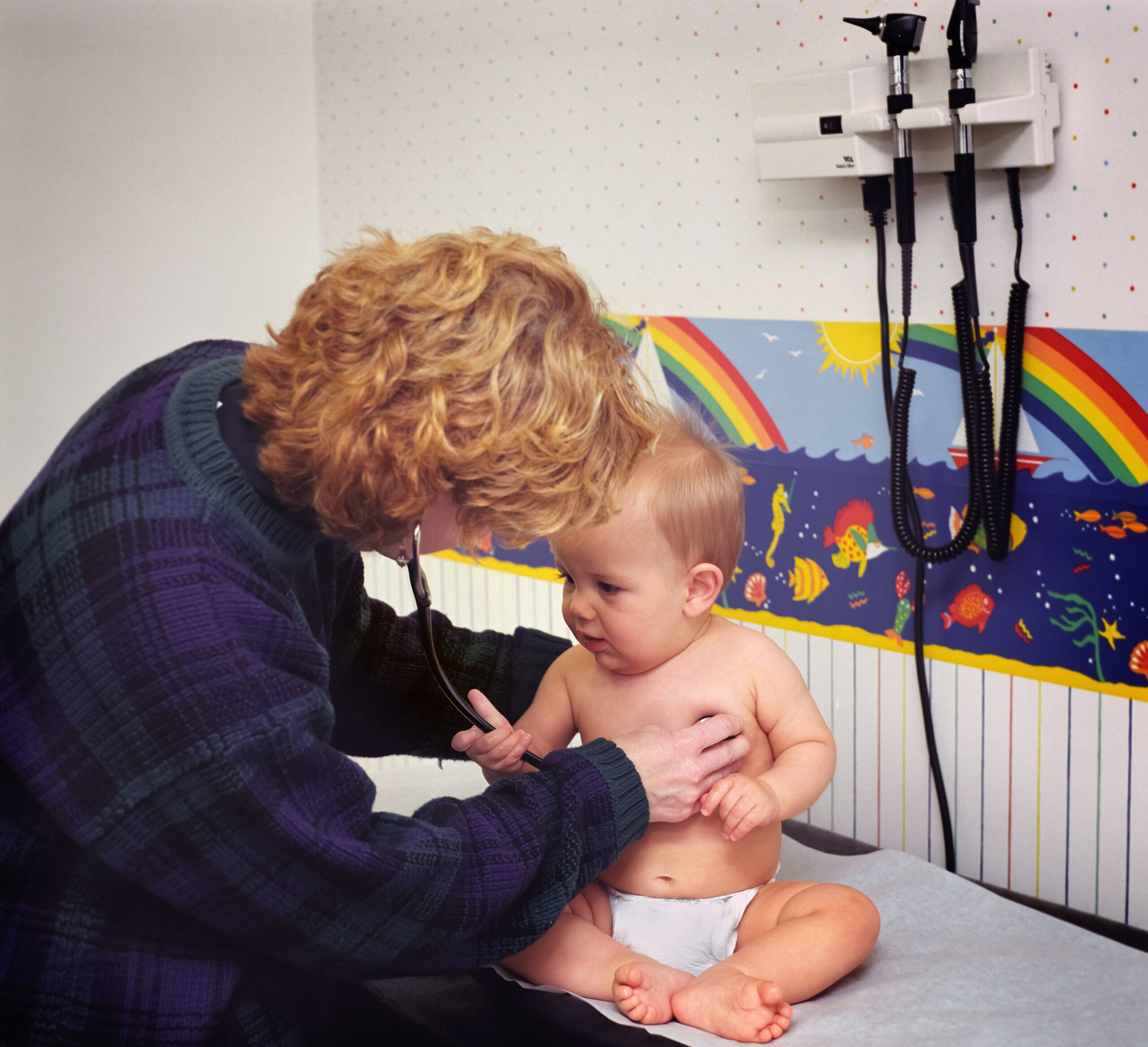 A doctor checks a newborn for common orthopedic injuries