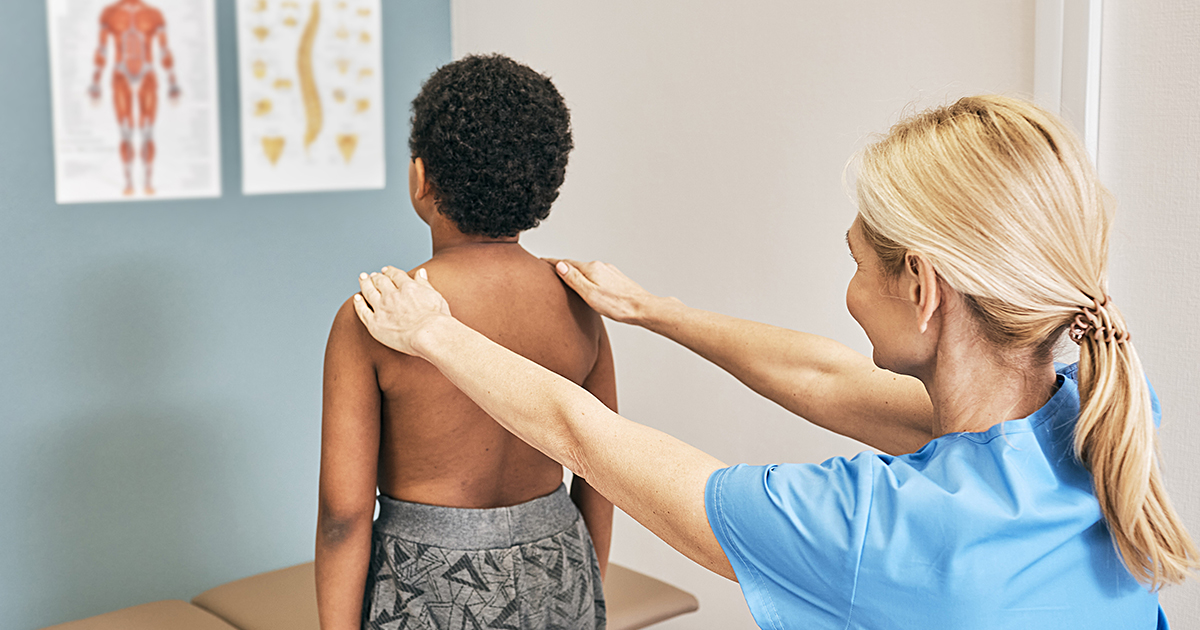 nurse reviewing a child's spine in a doctor's office