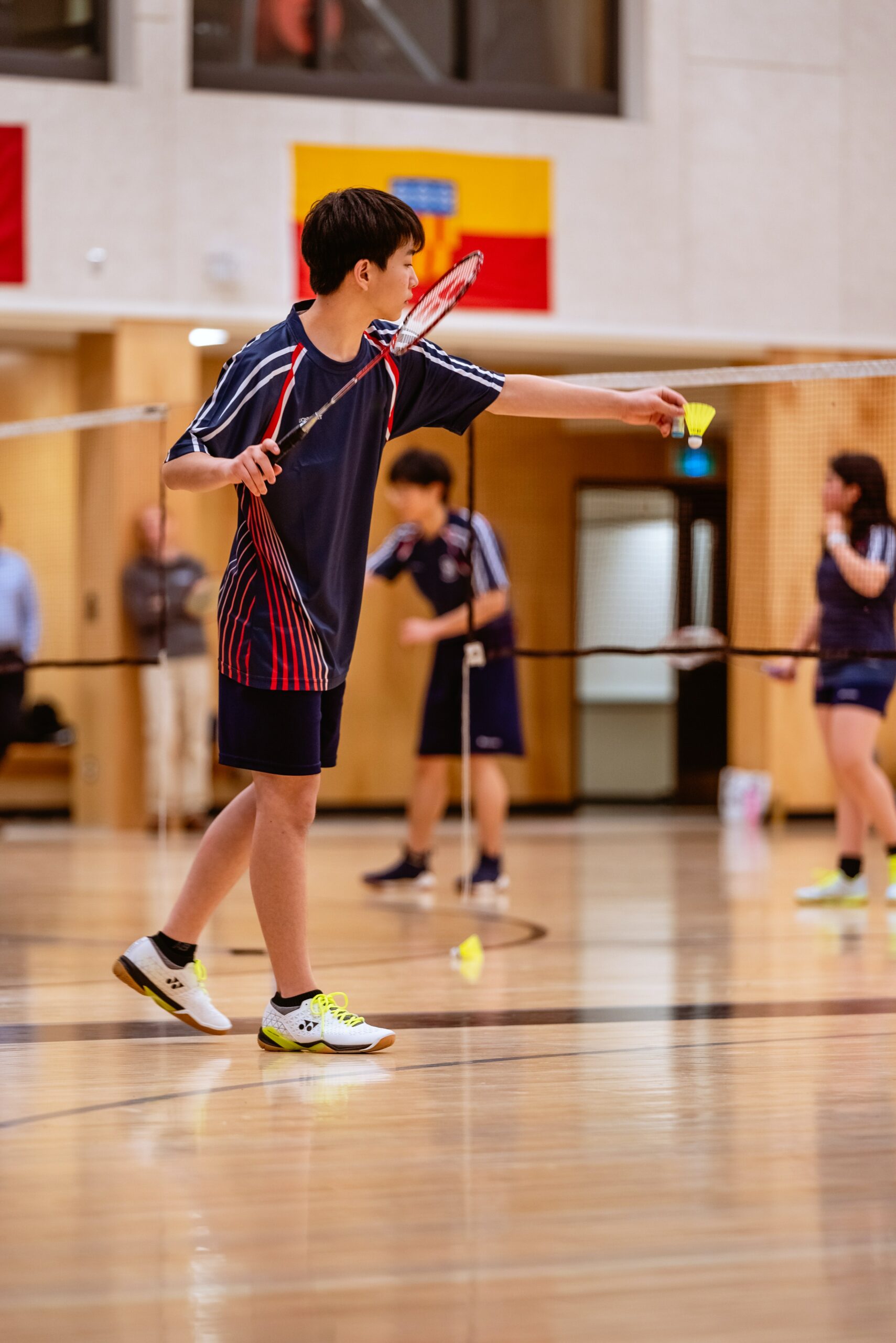 A student plays badminton in gym class