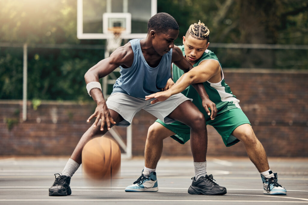 Two youth play a game of basketball