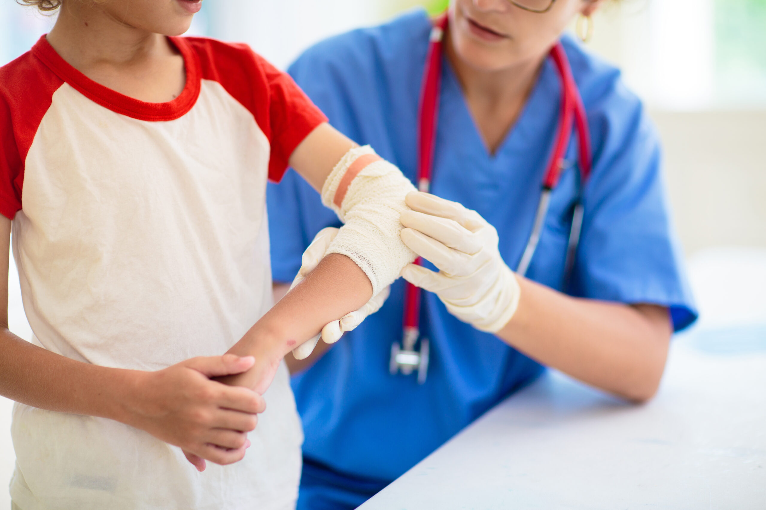 Nurse tends to a kid with an elbow cast at health clinic.