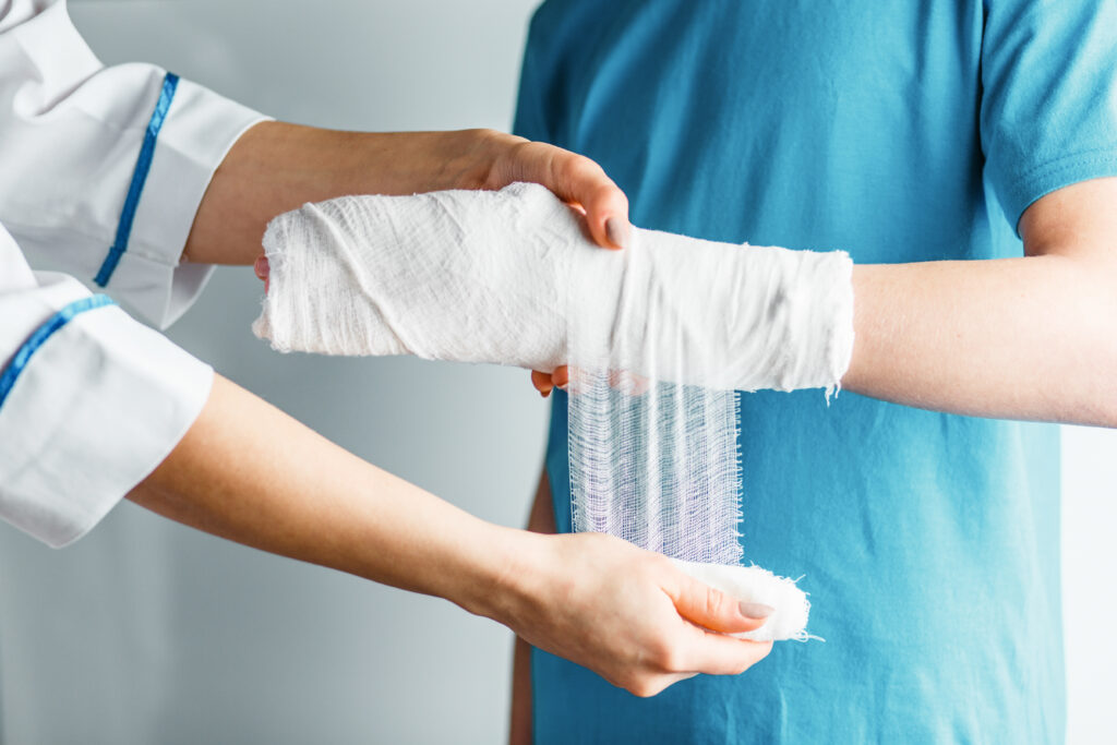 A nurse bandages a teen's hand