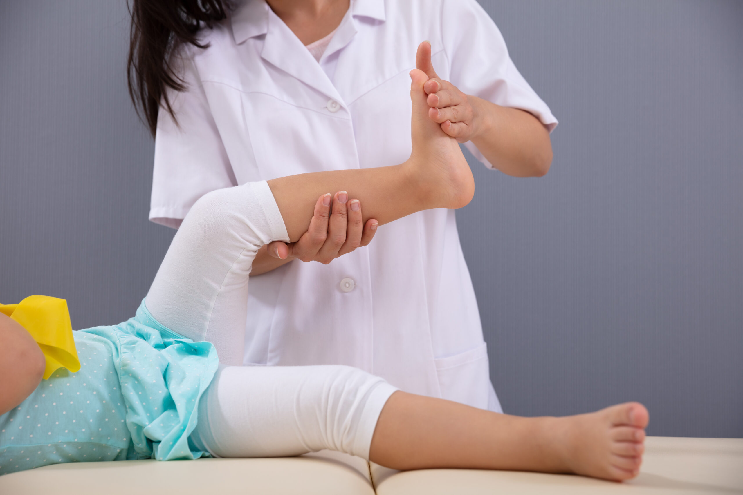Close-up Of A Female Physiotherapist Massaging Patient Girl's Foot