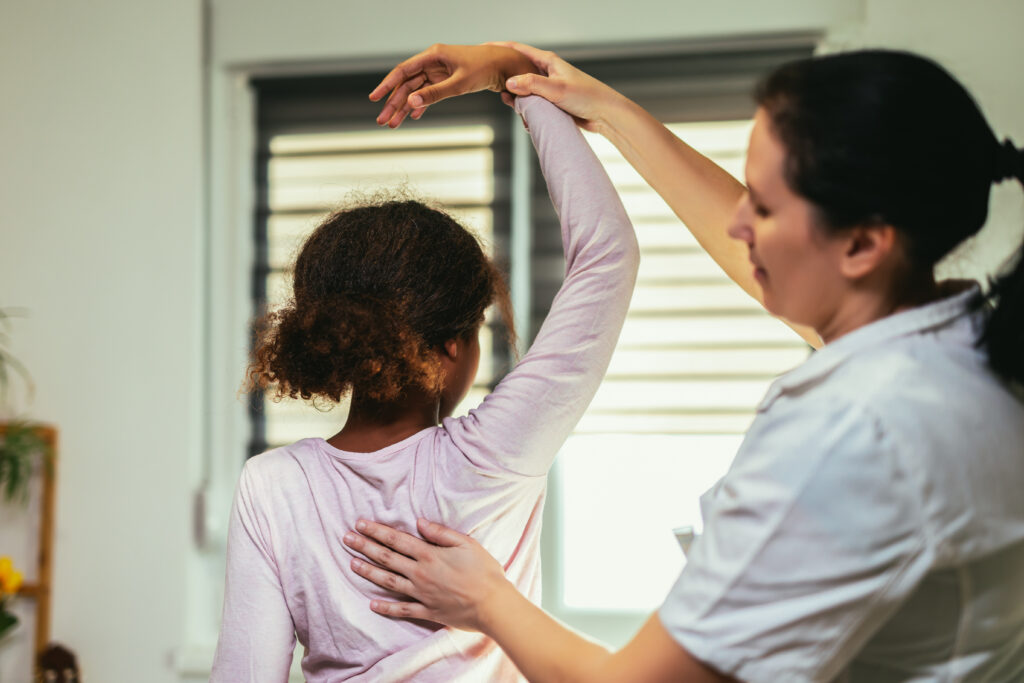 Teen Girl having chiropractic back adjustment. Osteopathy, Physiotherapy, Kinesiology. Bad posture correction