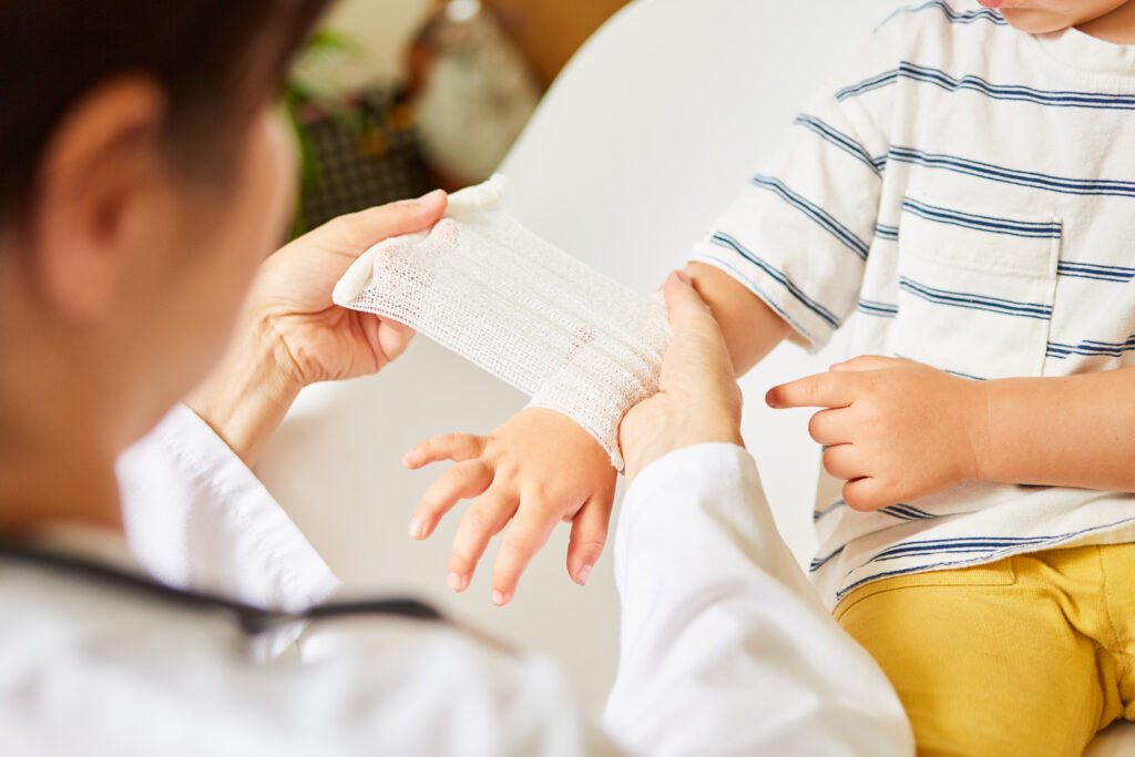 Pediatrician wraps bandage around child's wrist in the event of a sprain or accident